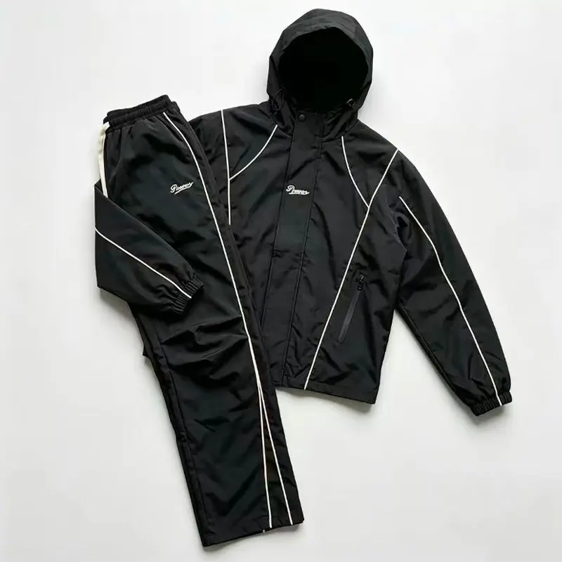 Men’s black two-piece athletic set with hood—streetwear casual style featuring contrasting white lines, minimalist letter embroidery, drawstring hood design, zippered pockets, elastic waistband cuffs, and a loose, relaxed fit. Suitable for young and middl