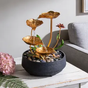 Metal lotus circulating tabletop fountain with warm yellow ambient light. Gentle running water builds tranquil zen atmosphere, elegant mini water decor for office, living room & meditation corners.