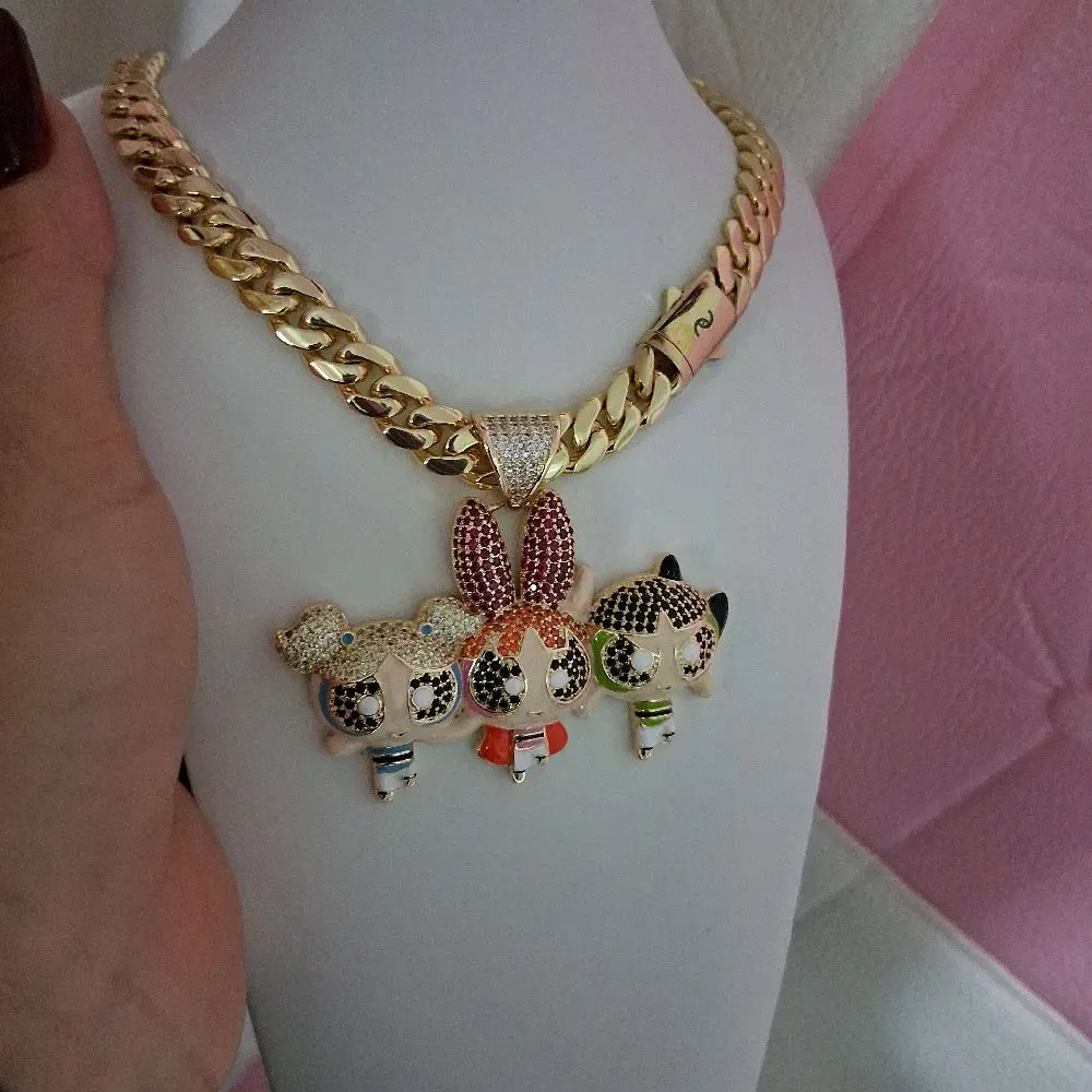 Gold plated chain ,10 millimeters thick 16 inches long with a cartoon pendant featuring three figures