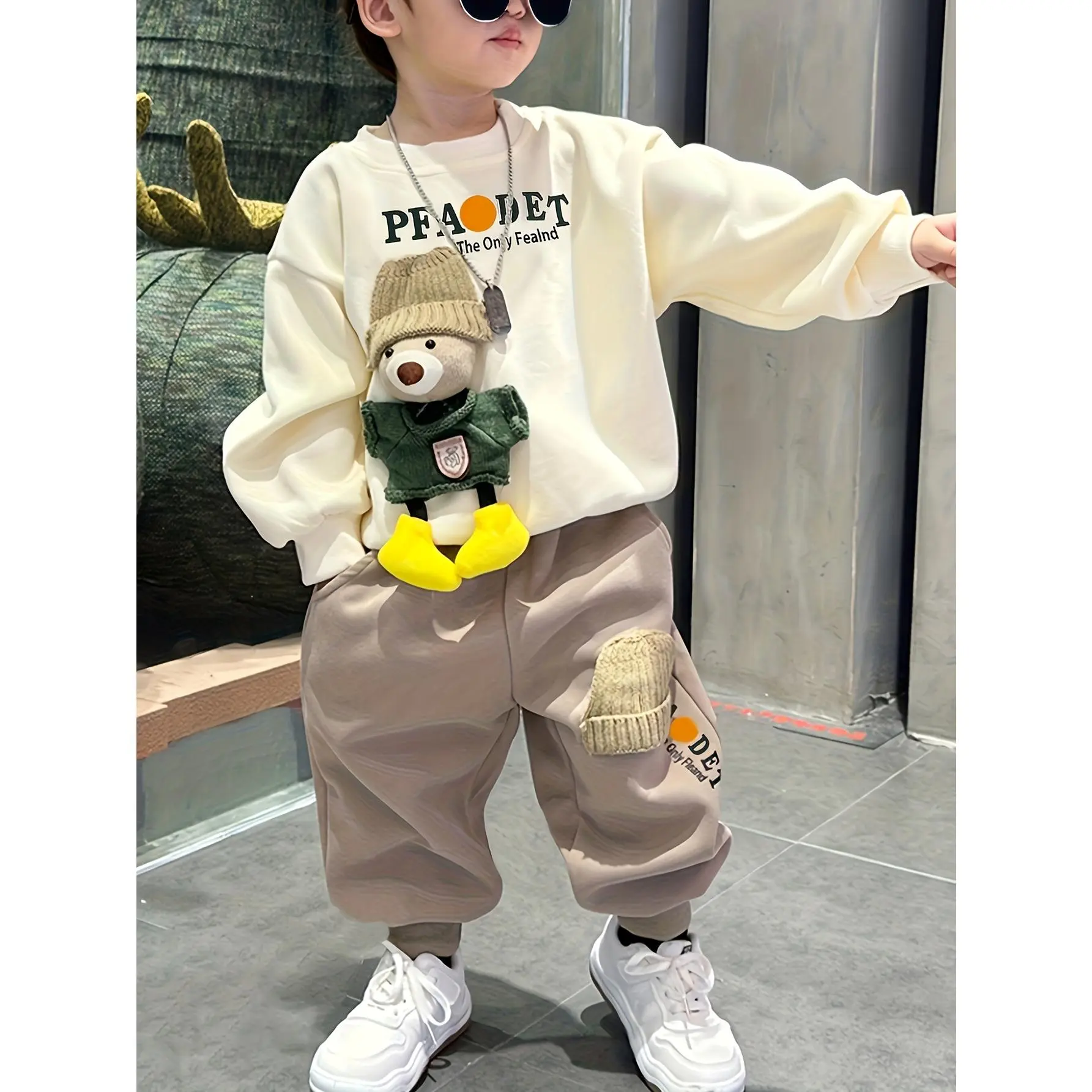 A Outfit Featuring a Round-Neck Sweatshirt And Khaki Tapered Pants, Designed with Letter Prints And Cartoon Bear Additions.It Has a Casual Style Suitable for Various Outdoor Activities, Perfect for Boys in Autumn And Winter, for Outdoor