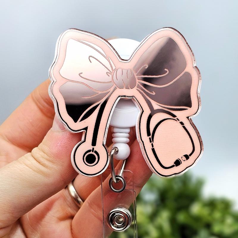 Bow with Stethoscope Badge Reel, Laser Engraved with Smooth Mirror Finish, Funny Badge reel for nurses, xray techs and hospital workers. Retractable swivel clip with a 360 rotation. Great gift for coworker. Cute Badge for Work. Badge clip, Badge pull