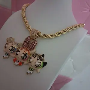 Gold plated chain ,6millimeters thick 17  inches long with a cartoon pendant featuring three figures