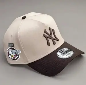 9FORTY New York World Series Side Patch Baseball Cap – Cream & Brown, Adjustable Size, Brown NY Logo.