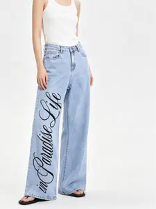 In Paradise Life Cursive Slogan Direct Spray Print High Waist Wide Leg Light Wash Denim Casual Pants