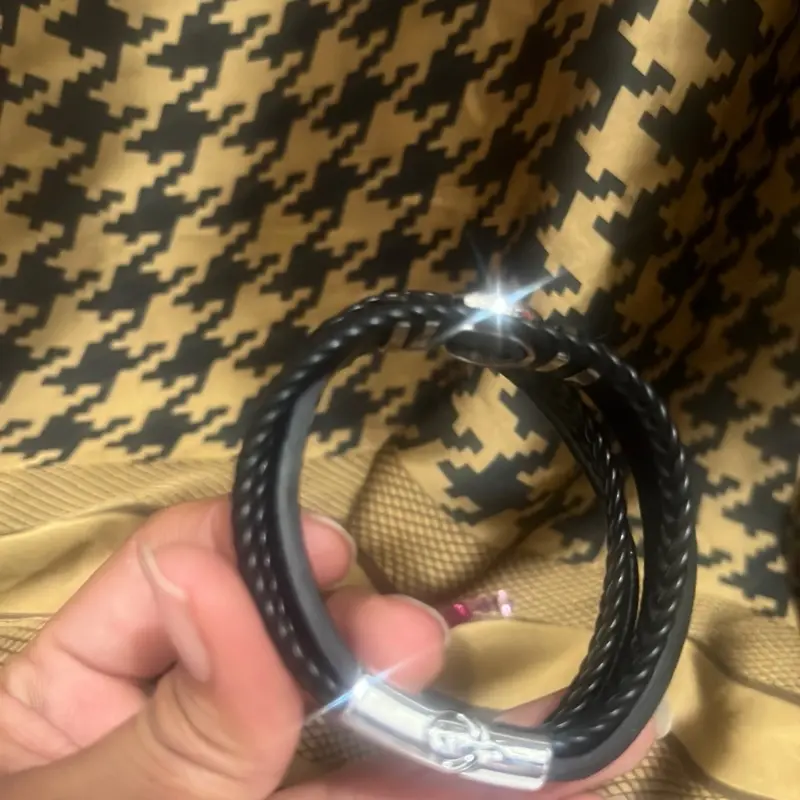 Stylish Black Leather Bracelet with Tree of Life Charm  Add a touch of meaning and style to your look with this elegant black leather bracelet. Crafted from high-quality braided and smooth leather strands, it features a striking silver-tone Tree of Life c