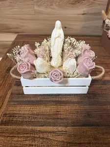 Floral arrangements in a candle with the Virgin Mary