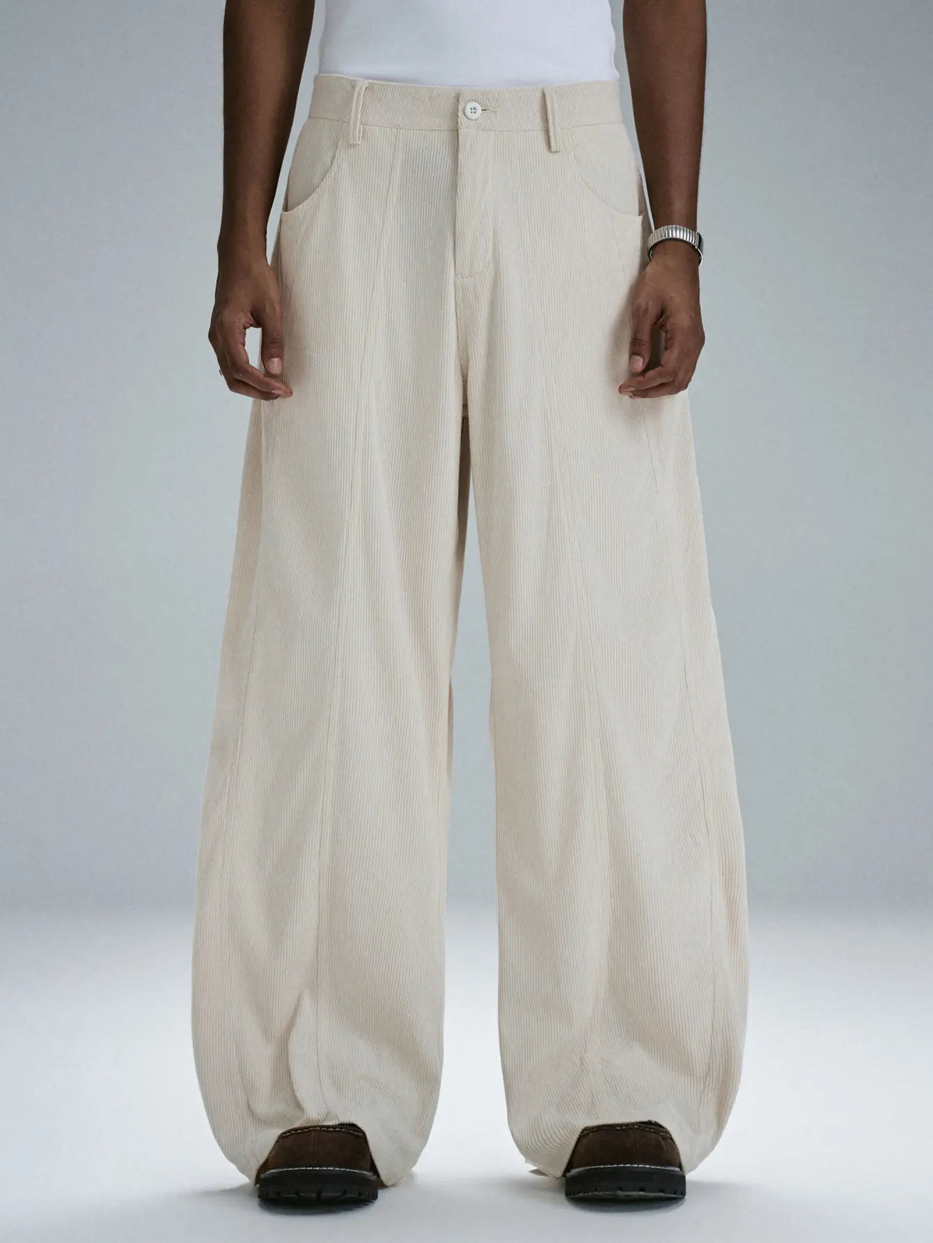 One men’s off-white corduroy wide-leg pants in a retro casual style, featuring a vertical ribbed texture and a split design, with a loose curved cut and side pockets—suitable for everyday outings, offering a soft feel.