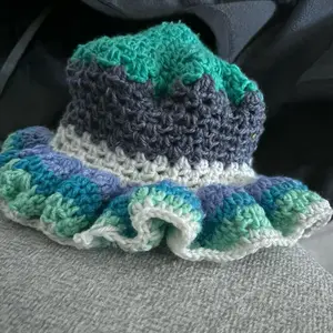 Blaira Knit Hat with Colorful Design and Decorative Trim in Various Colors Including Green, Teal, Gray, and White