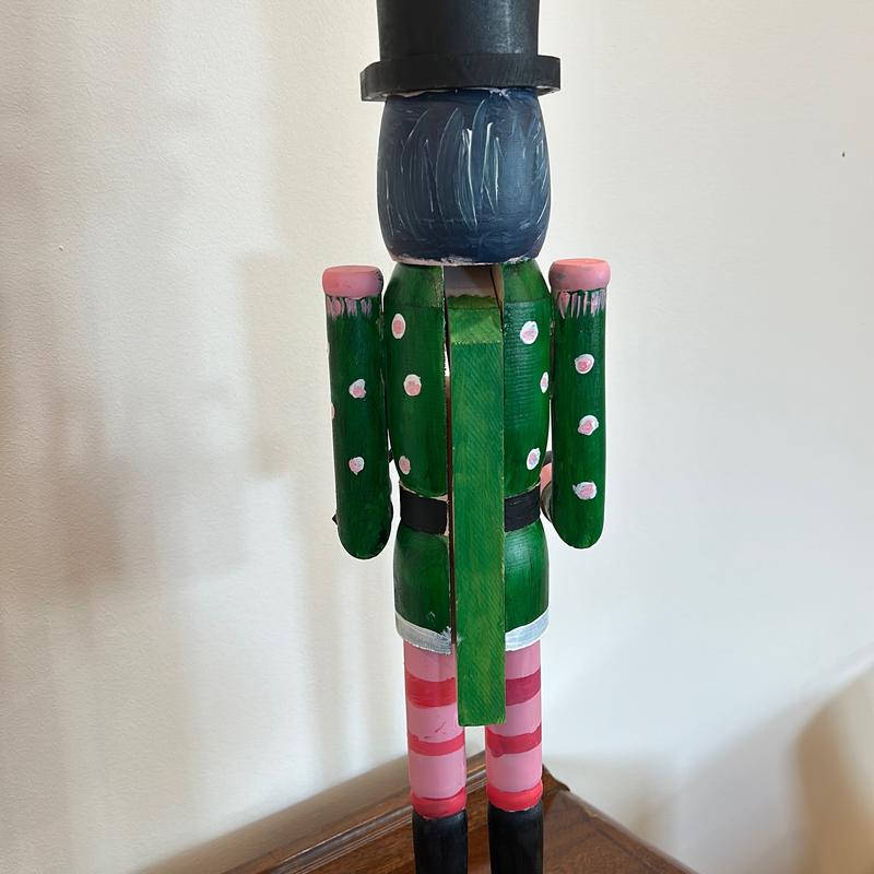 Hand-painted wooden nutcracker. He measures 24 inches tall. “Gunner” is a handsome guy that absolutely can live in your space year round.
