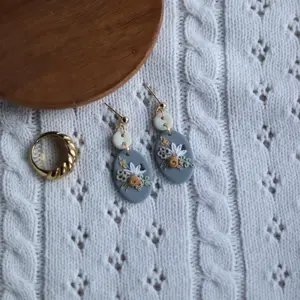 Floral Polymer Clay Earring Trending Earrings Flower Jewelryry on Elegant Knit Fabric Background