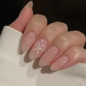 Elegant Nude Pink Almond Nails with Delicate White Bow Design and Subtle Rhinestone Accent – Minimalist yet Chic Nail Art for Everyday Wear, Bridal Looks, Feminine Touch with a Hint of Sparkle for Graceful and Timeless Style