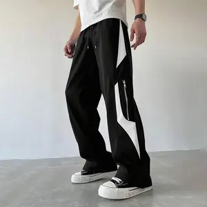 A black and gray patchwork wide-leg casual pant, featuring an urban leisure style. The black and gray color scheme is sophisticated and understated, appealing to city dwellers' fashion sensibilities. The patchwork design and zipper pocket details add a to