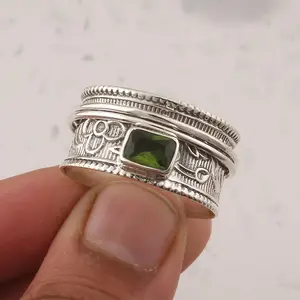 Vintage-inspired wide band ring with an antique finish—a classic Bohemian-style accessory featuring a square-cut emerald-simulated stone. The band is intricately engraved with floral patterns, making it a collectible piece of exotic jewelry.