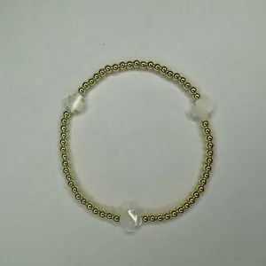 The Glow bracelet CROSS - 6.5” stretchy bracelet Made with: 3mm round gold plated hematite beads with 8mm white color mother of pearl cross beads