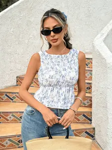 Fresh Blue White Floral Smocked Peplum Vacation Sleeveless Blouse Trendy Blue White Floral Smocked Cropped Statement Vacation Top Elegant Blue White Floral Smocked Peplum Resort Sleeveless Blouse