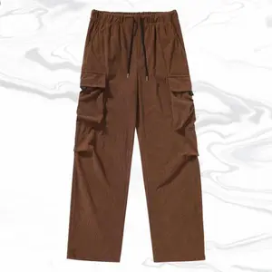 A pair of coffee-colored corduroy multi-pocket work pants, featuring a retro trendy style with drawstring waist details that are both vintage and fashionable. The large side pockets ingeniously blend retro workwear with trendy elements. Made of corduroy