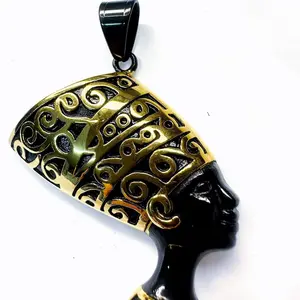 Maite Jewelry                                               Nefertiti Pendant                                          Elegant Gold and Black Design with Intricate Swirls and Unique Shape