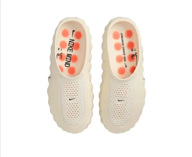 Solid cream slip-on clogs, hollow breathable panels, curved wavy sole, lightweight and water-friendly design.