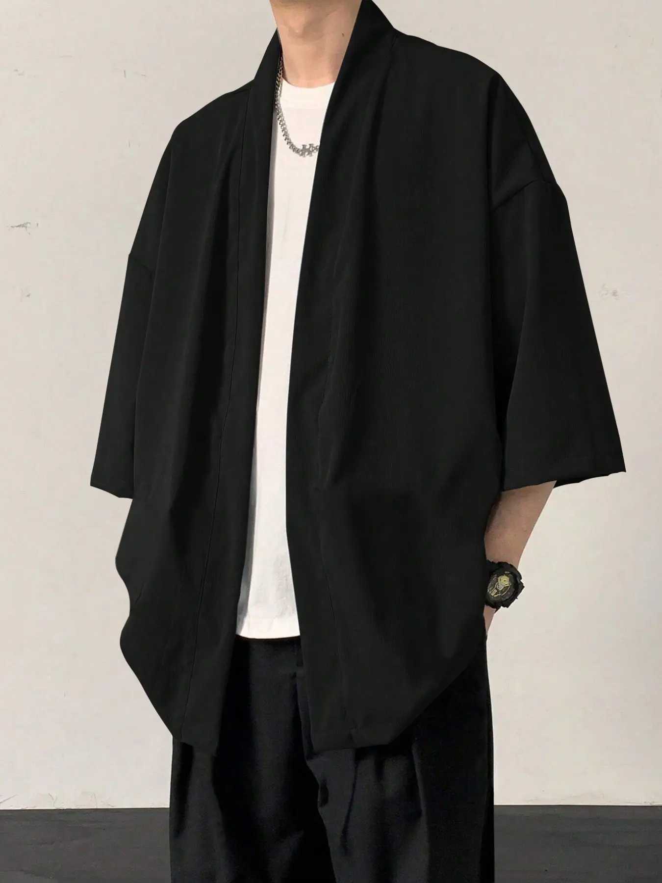 A solid-color, drop-shoulder men's shirt or a loose-fitting solid black linen shirt is an ideal choice for autumn wear.