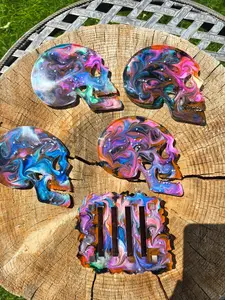 Resin skull coasters and stand. This set includes 4 coasters and their stand.
