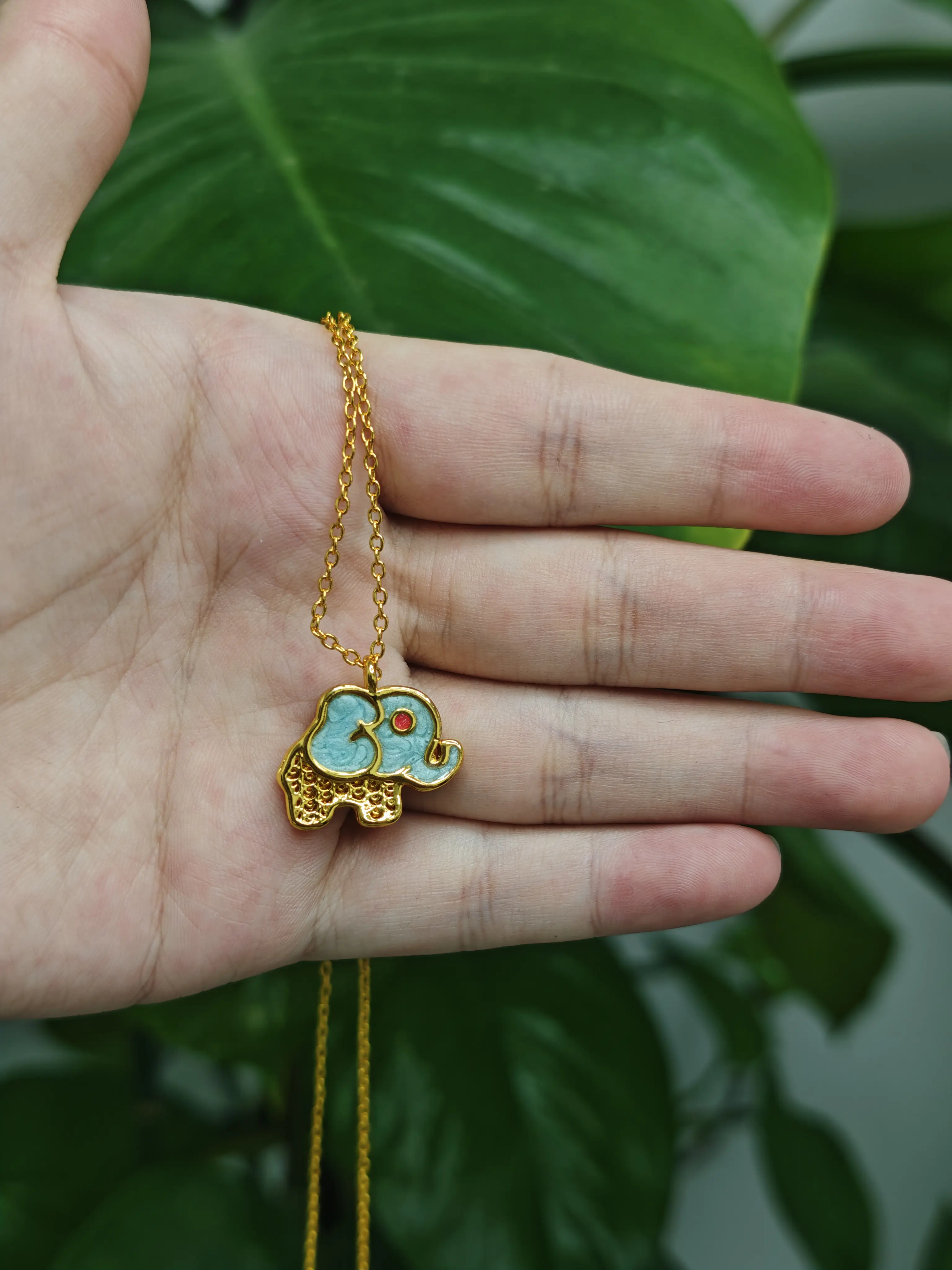 Casha(21365)gc.Gold‑tone enamel elephant pendant. Cute design, stands for peace and good luck.