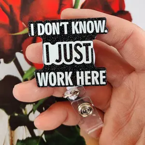 A humorous work card retractable buckle, the main body is a black design with glitter, printed with white text "I DON'T KNOW! I JUST WORK HERE (I don't know! I just work here) " Equipped with a retractable structure and a transparent clip,