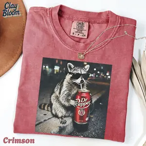 Cool Raccoon with Sunglasses Drinking Dr Pepper T-Shirt | Trendy Unhinged Animal Meme Graphic | Comfort Colors By Clay Bloom Soft Wash Fabric Tee | Retro 90s Style Streetwear | Perfect Birthday Gift for Raccoon Lovers and Soda Fans - By Clay Bloom
