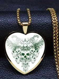 A transparent glass heart necklace with an intricate 2D skull design inside.