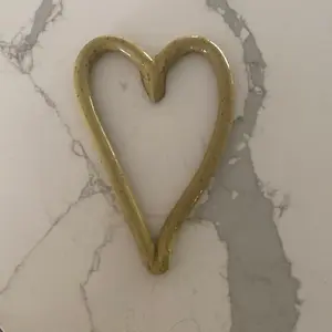 Tiny handmade pottery heart, glazed in warm yellow with natural rustic texture. Each piece is unique, shaped by hand to represent a simple message: love over hate. Imperfect, authentic, and made with care. A small reminder that kindness (product varies)