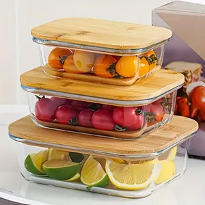 A Set of Three Rectangular Bamboo And Wood Lid Containers (12.51oz + 21.64oz + 35.17oz) Made of High Borosilicate Thick Glass for Food Storage. They Feature Leak-Proof Sealing Lids, Are Stackable, Reusable, And Durable