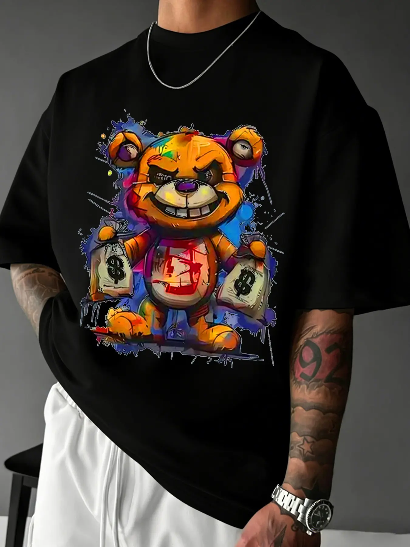 Unisex design. Street style, Streetwear, summer comfort, round neck, short-sleeved Fitted T-shirt. Trendy, money-themed graffiti with a bear design. Urban fashion piece. Couple-friendly, suitable for campus, hip-hop, and everyday wear.