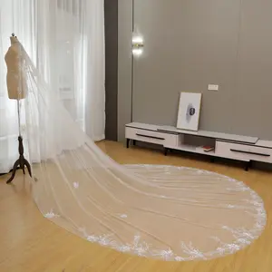 A delicate bridal veil features sparkling sequins and beads embellished in a floral and leaf pattern at the hem.