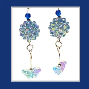 Faceted blue acrylic beads with flashes of lavender earrings include glass butterflies and crystal spacers