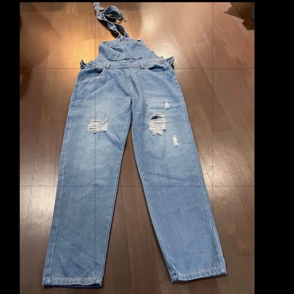 Women's ripped denim overall. Available in size Small to Large