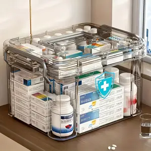 A Durable Double-Layer Medicine Storage Box with a Handle, Featuring a Transparent Gray Waterproof Design. It Has an Easy-Open Lid for Home Or Travel Use, Multiple Compartments for Organizing Emergency Supplies And Medications, And Clear Visible Sections