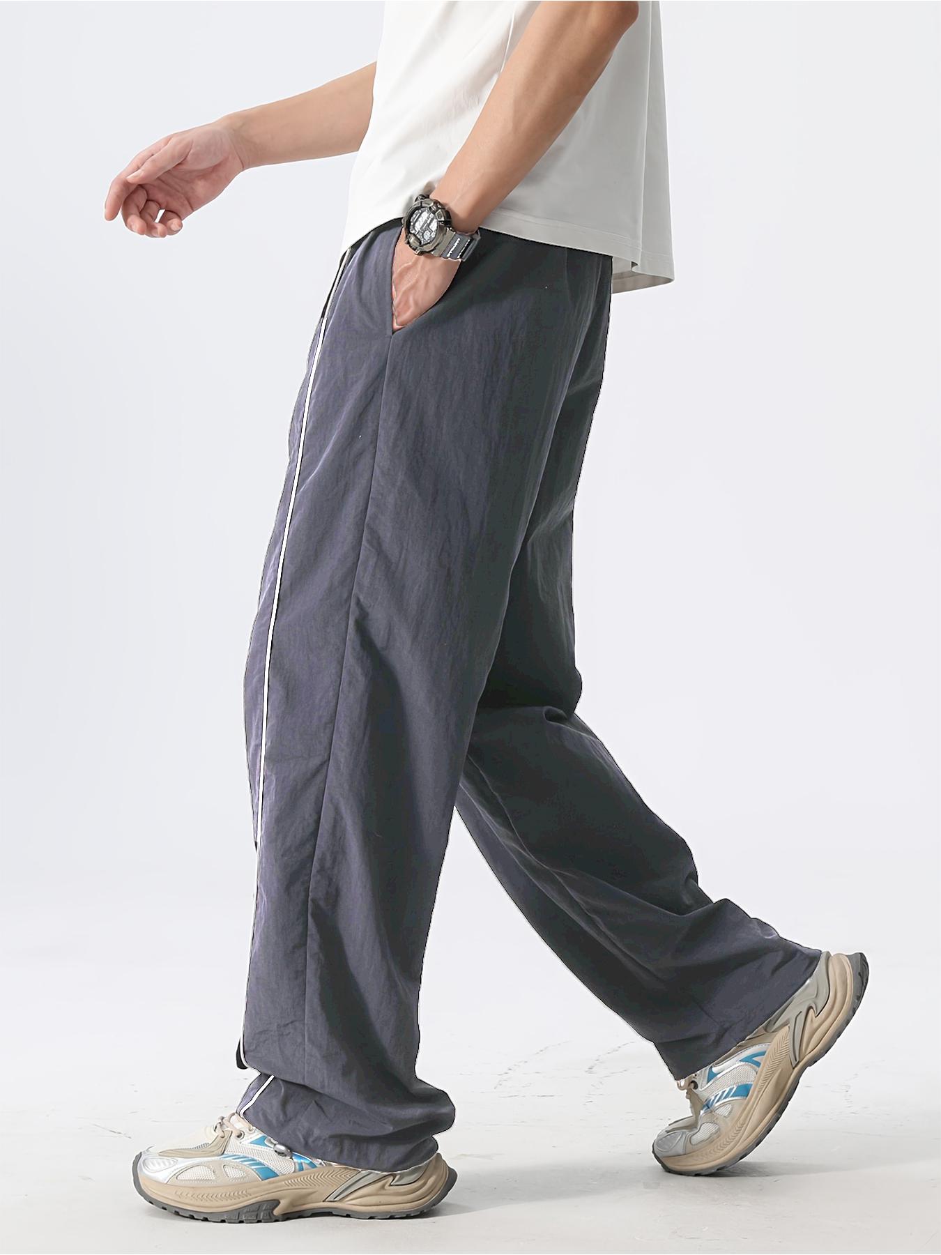 Men’s fashion loose fit long pants with side stripe paneling, drawstring waist, and elastic cuffs—perfect for everyday casual wear.
