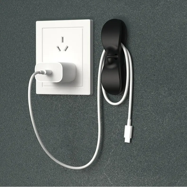 No-drill cable winder and organizer; wall-mounted plug hook; holder for managing power cords and data cables; cord organizer for TVs, computers, and small appliances; essential home and desktop cable management tool.