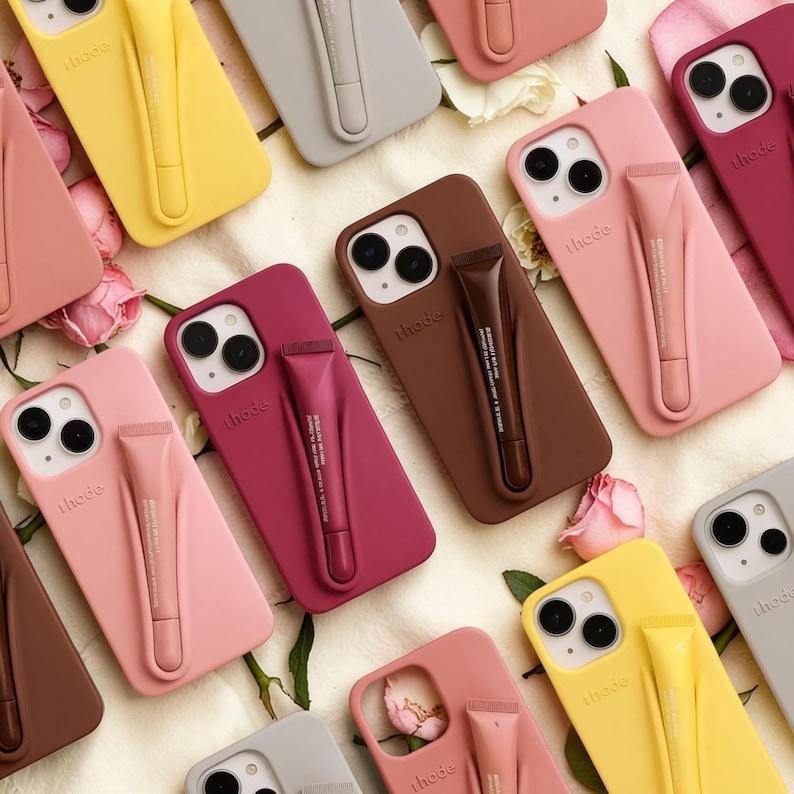 Rhode Style Lip Gloss Holder Phone Case for iPhone 11–17 Pro Max, Soft Silicone Makeup Storage Cover, Cute Aesthetic Beauty Essential – Selling Fast, Don’t Miss Out