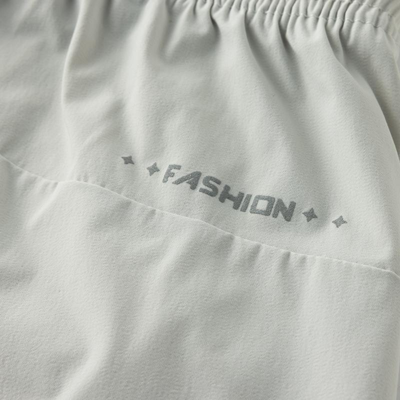 Men’s solid-color casual shorts with zippered pockets; summer fashion drawstring athletic shorts suitable for fitness and outdoor wear; comfortable shorts with a casual, minimalist style featuring letter print and drawstrings.