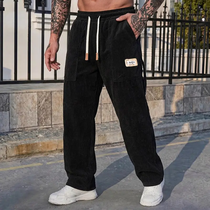 Men’s corduroy wide‑leg trousers with tag decoration and drawstring waist, suitable for outdoor wandering and daily commuting, work well as a vintage‑style outfit