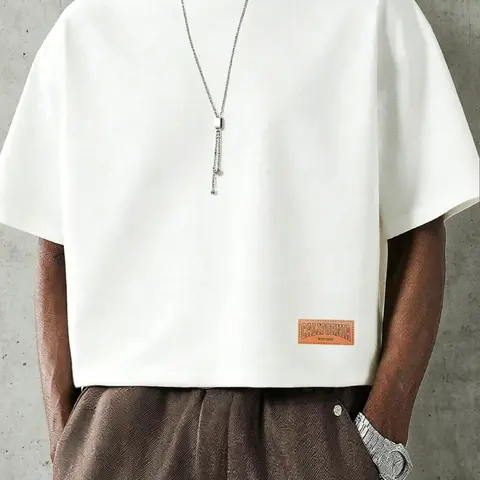 A cropped T-shirt, Crewneck, Round neck, Menswear, Streetwear, featuring seamless batwing short sleeves and a leather-textured graphic, with minimalist casual aesthetic, perfect for occasions from vacations to everyday wear, Streetwear Graphic Tees