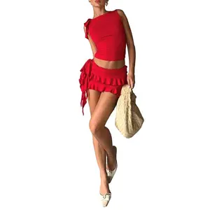 Women’s summer two-piece set: solid-color sleeveless shoulder-strap top paired with a pleated red polyester mini skirt featuring a plaid pattern.
