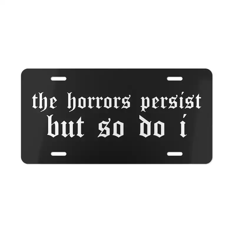 Aluminum Front License Plate with "The Horrors Persist But So Do I" Quote Print, Cute Gothic Black Vanity Plate, Witchy Cars Accessories for Car Decorating, Quirky Vehicle Gift, Cute Car Decor