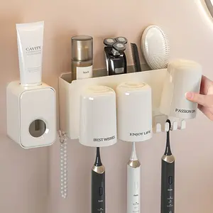 Cream White Wall-Mounted Toothbrush Holder with Automatic Toothpaste Dispenser. No-drill, strong adhesive, damage-free installation. One-press hygienic dispensing, large capacity storage tray. Modern, clean bathroom organizer set.  home must-haves.