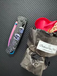 535 Outdoor Multi-Tool, carbon-fused handle, 3D-printed skull texture, laser-etched patterns with vibrant hues, vacuum-coated to achieve a titanium-like purplish-red finish, made of high-hardness Damascus steel