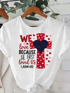 T-Shirt Featuring a Cross, Heart, And The Bible Verse 'We Love Because He First Loved Us' from 1 John, Made of 180G 100%, Suitable for Both Men And Women, Perfect for a Religious Valentine'S Day
