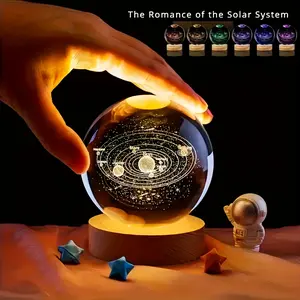 A 3D laser-engraved glass ball with solar system and starry sky designs, equipped with a USB-powered wooden base, can be used as a glowing night light. It is an ideal gift for a girlfriend, wife, friend, or for occasions like Thanksgiving