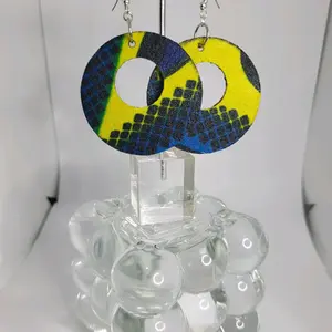 Lightweight wooden earrings in an array of African prints. Blues with yellows, blues with yellows and pinks, greens with pinks and yellows, and navy blue's with greens and yellows. A variety to choose from.