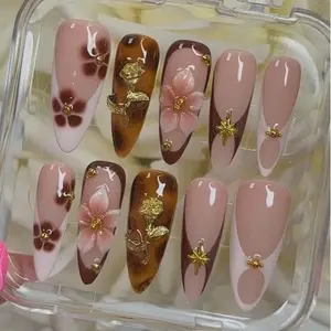 Luxurious nude and mocha brown press on nails with tortoiseshell accents, 3D floral art and gold charm details for an elegant autumn romantic feminine aesthetic manicure style