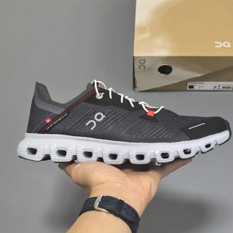 Retro running sneakers with flexible segmented shock-absorbing athletic silhouette, premium breathable knit mesh finished in matte black paired with crisp white laces and slim red stitching accents, hollow cushioned foam midsole